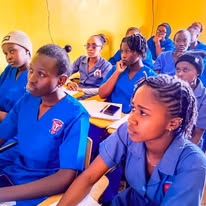 KCT nursing students in blue uniforms seated in the front row of a classroom
